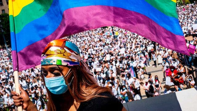 mujer ondeando bandera LGBTQ