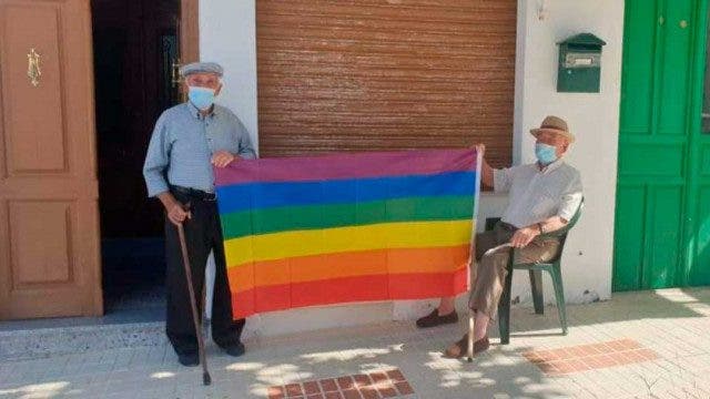 Viejitos posando con la bandera de colores