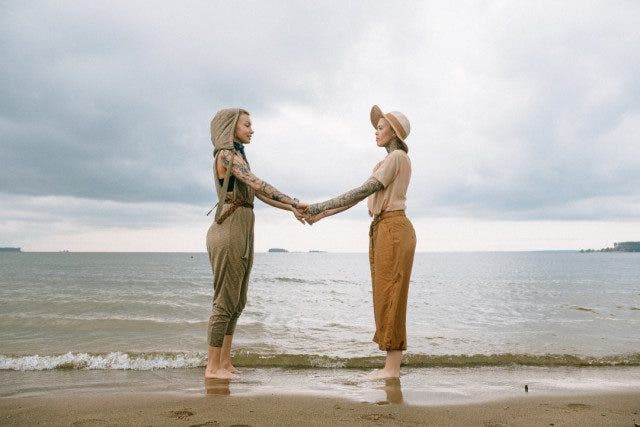 women holding hands at the beach 3727542