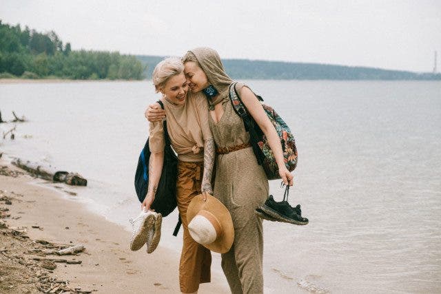 photo of women embracing while standing on beach 3727541