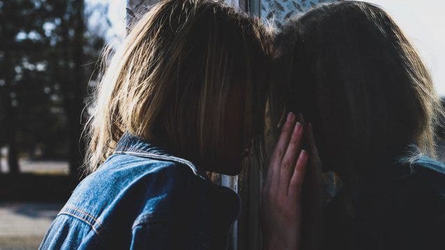 Mujer triste mirando por la ventana