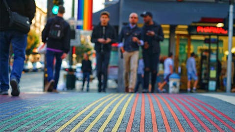 personas caminando por un paso de peatones de colores