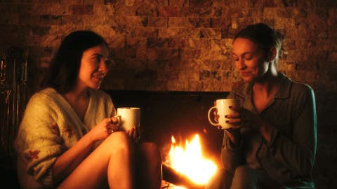 pareja lésbica frente a la chimenea