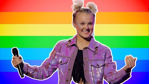 Jojo Siwa con una bandera LGBTQ de fondo